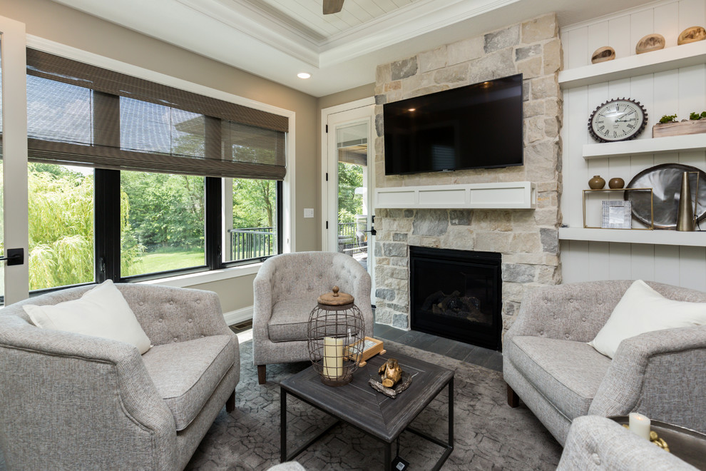 This is an example of a medium sized classic games room in Other with beige walls, dark hardwood flooring, a standard fireplace, a stone fireplace surround, a wall mounted tv and grey floors.