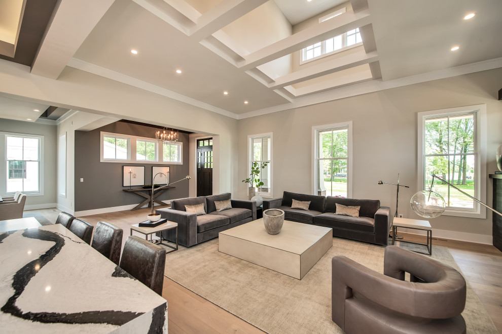 This is an example of a medium sized contemporary open plan games room in Columbus with light hardwood flooring, brown floors and exposed beams.
