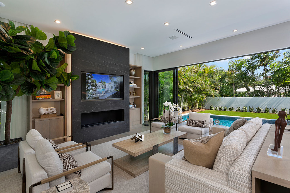 This is an example of a medium sized contemporary open plan games room in Miami with a reading nook, green walls, medium hardwood flooring, a ribbon fireplace, a stone fireplace surround, a wall mounted tv and brown floors.