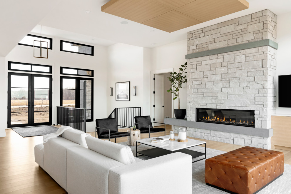 Idée de décoration pour une salle de séjour design ouverte avec parquet clair, une cheminée standard, un manteau de cheminée en pierre et un sol marron.