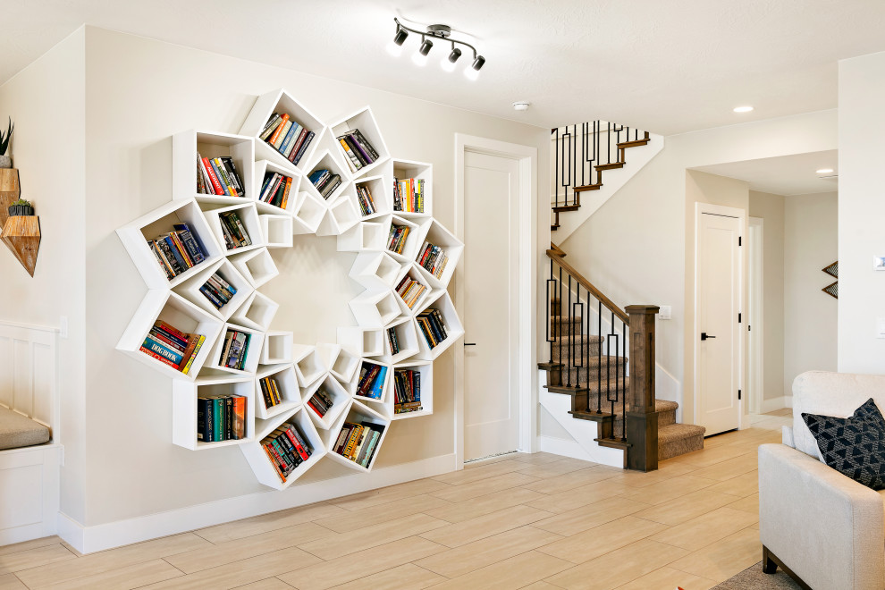 Idee per un soggiorno minimalista aperto con libreria, pareti beige, pavimento in gres porcellanato e pavimento beige