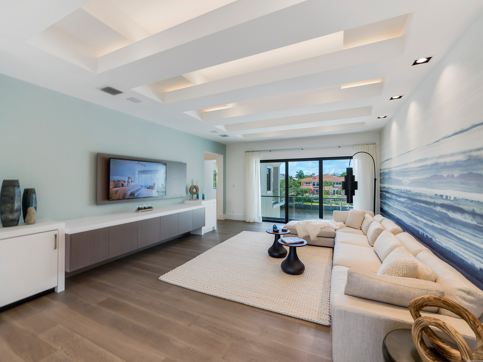 Immagine di un grande soggiorno minimalista aperto con pareti multicolore, pavimento in legno massello medio, TV a parete e pavimento marrone