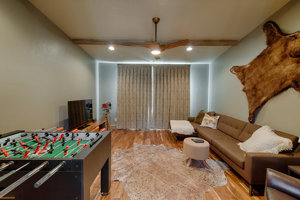 Uriger Hobbyraum ohne Kamin mit grauer Wandfarbe, braunem Holzboden und freistehendem TV in Boise