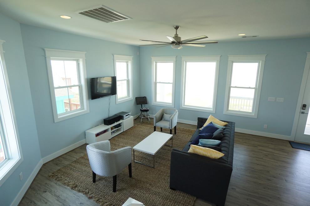Ispirazione per un soggiorno minimal di medie dimensioni e aperto con pareti blu, pavimento in legno massello medio, nessun camino e TV a parete