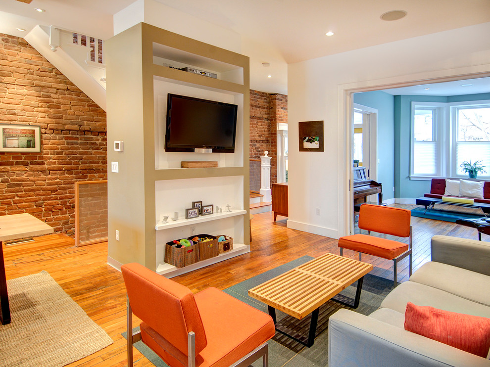 Ejemplo de sala de estar abierta contemporánea de tamaño medio sin chimenea con paredes blancas, suelo de madera en tonos medios y televisor colgado en la pared