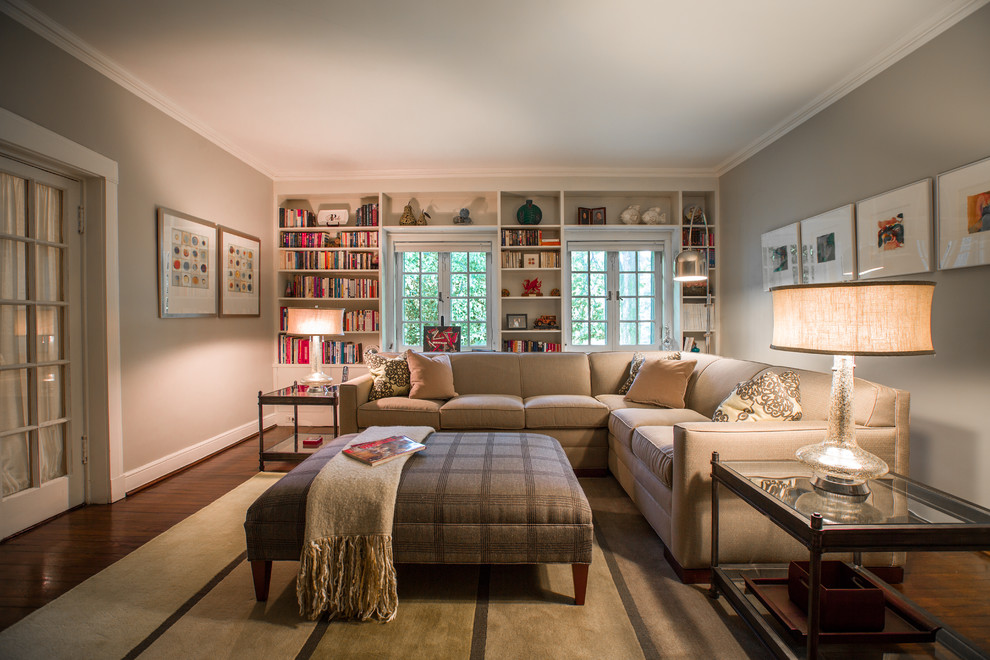 Immagine di un soggiorno tradizionale di medie dimensioni e chiuso con libreria, pareti grigie, parquet scuro e tappeto