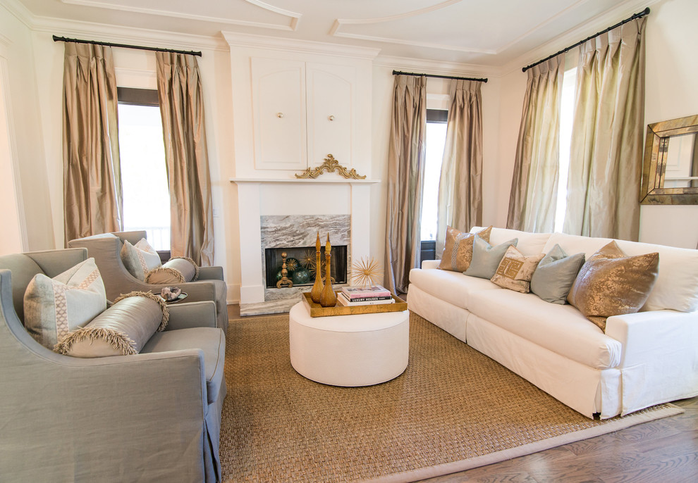 Imagen de sala de estar tradicional de tamaño medio con paredes blancas, suelo de madera en tonos medios, todas las chimeneas, marco de chimenea de piedra y televisor retractable