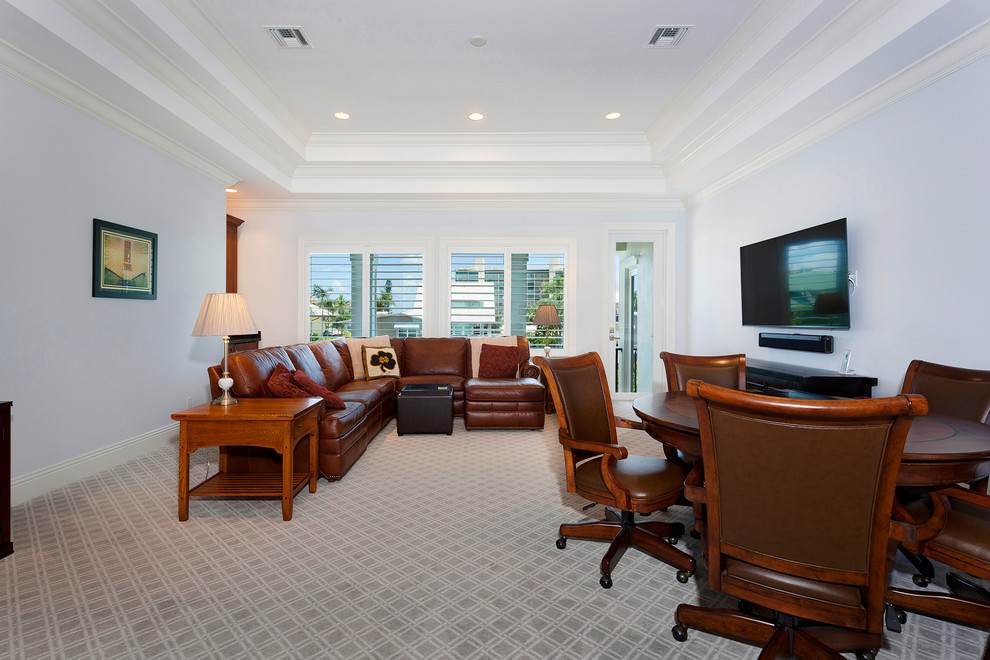 На фото: огромная двухуровневая гостиная комната в морском стиле с серыми стенами, ковровым покрытием, телевизором на стене и бежевым полом без камина