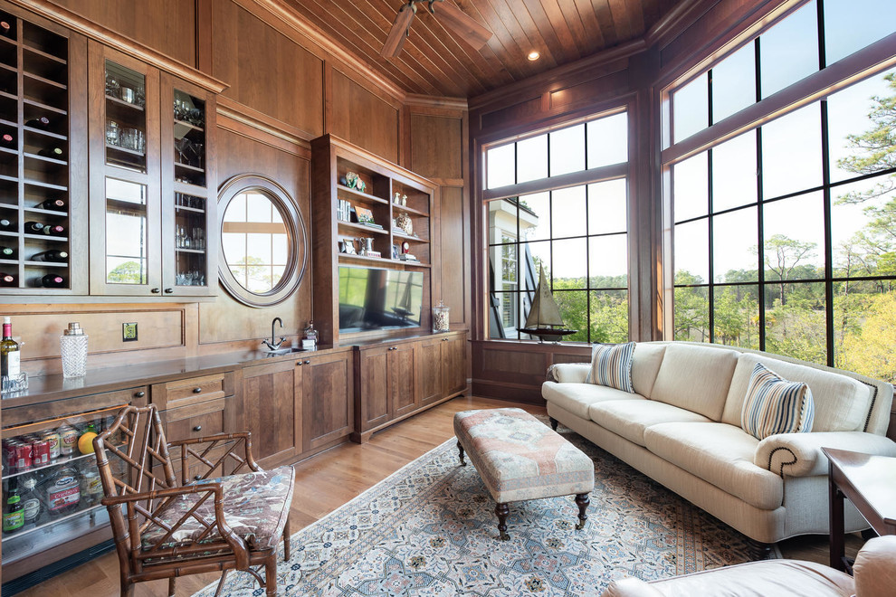 Klassisches Wohnzimmer mit Hausbar, brauner Wandfarbe, braunem Holzboden, TV-Wand und braunem Boden in Charleston
