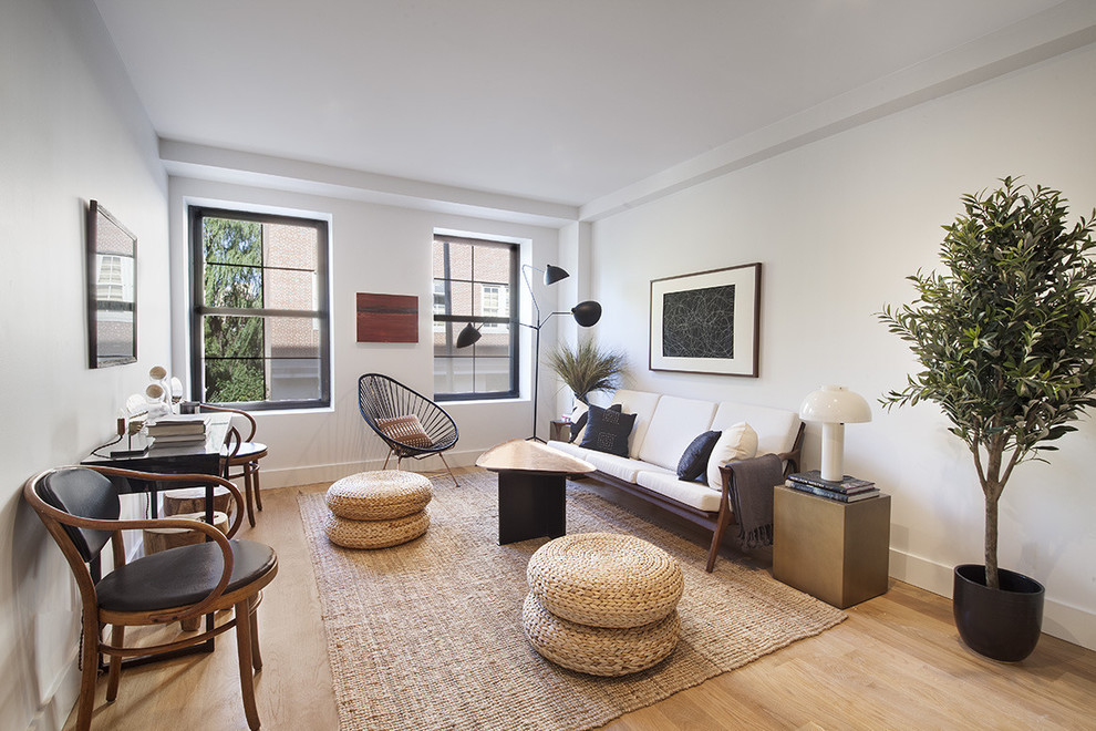 Offenes Modernes Wohnzimmer ohne Kamin mit weißer Wandfarbe und hellem Holzboden in New York