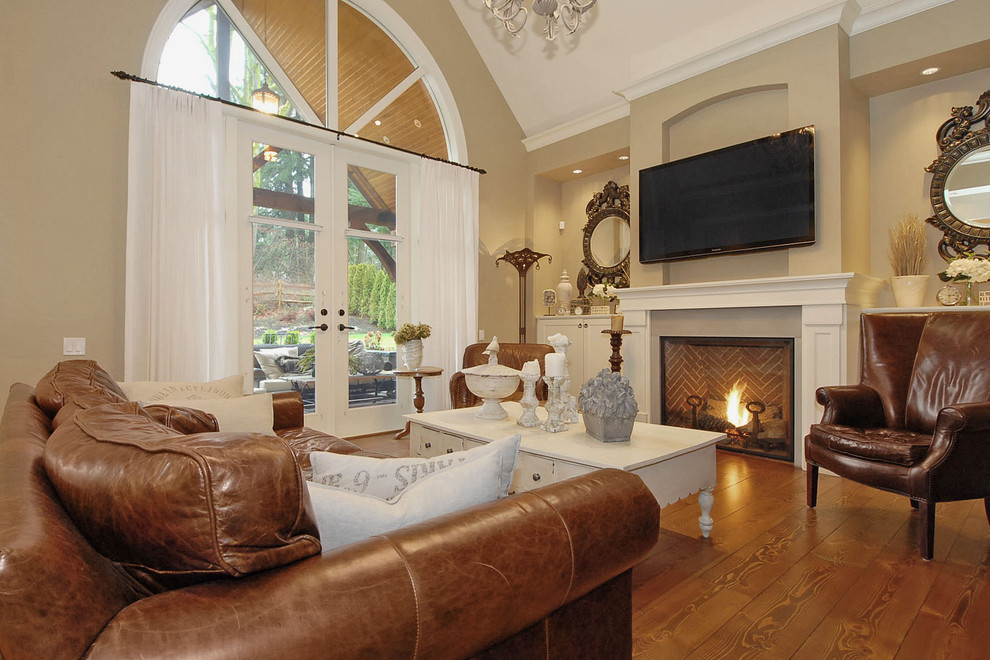 Ejemplo de sala de estar clásica con paredes beige, suelo de madera en tonos medios, todas las chimeneas y televisor colgado en la pared