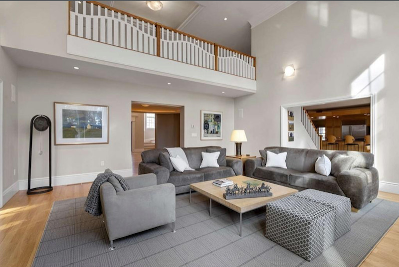 Aménagement d'une très grande salle de séjour craftsman ouverte avec un mur beige, un sol en bois brun et un téléviseur encastré.