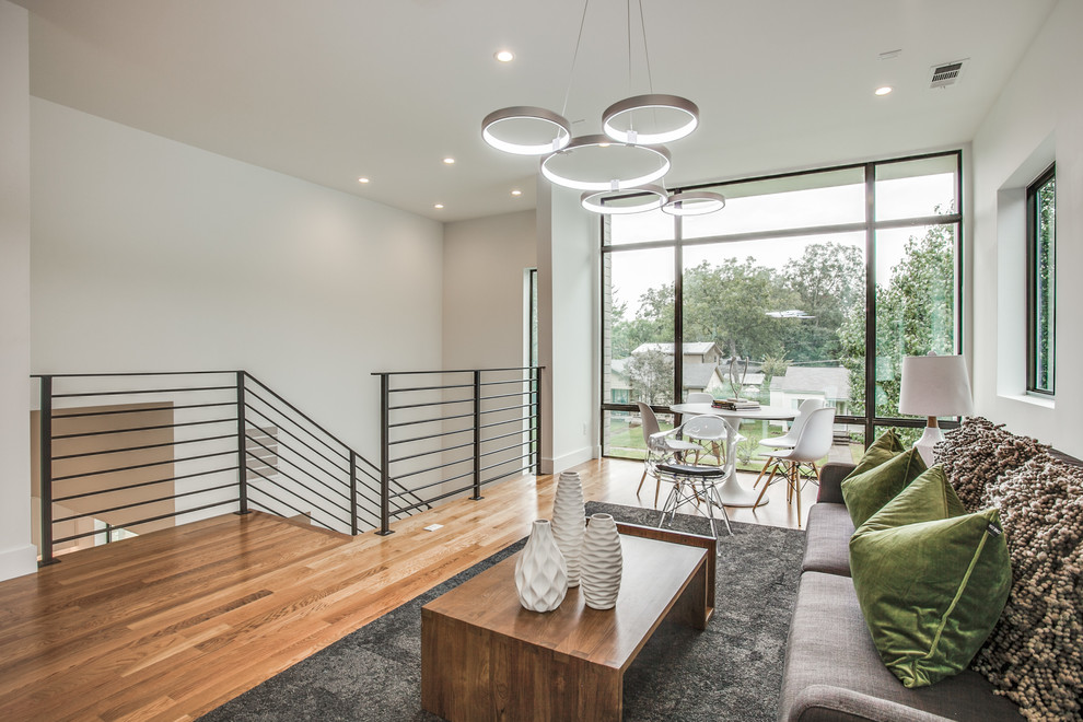 Ejemplo de sala de estar tipo loft moderna de tamaño medio con paredes blancas y suelo de madera en tonos medios