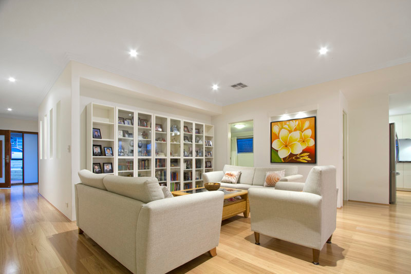 Diseño de sala de estar abierta clásica renovada con paredes beige y suelo de madera clara