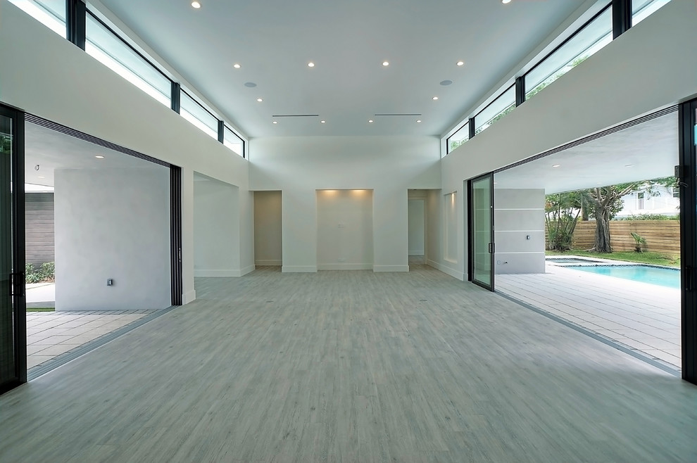 Ejemplo de sala de estar abierta contemporánea grande sin chimenea y televisor con paredes blancas, suelo de madera pintada y suelo gris