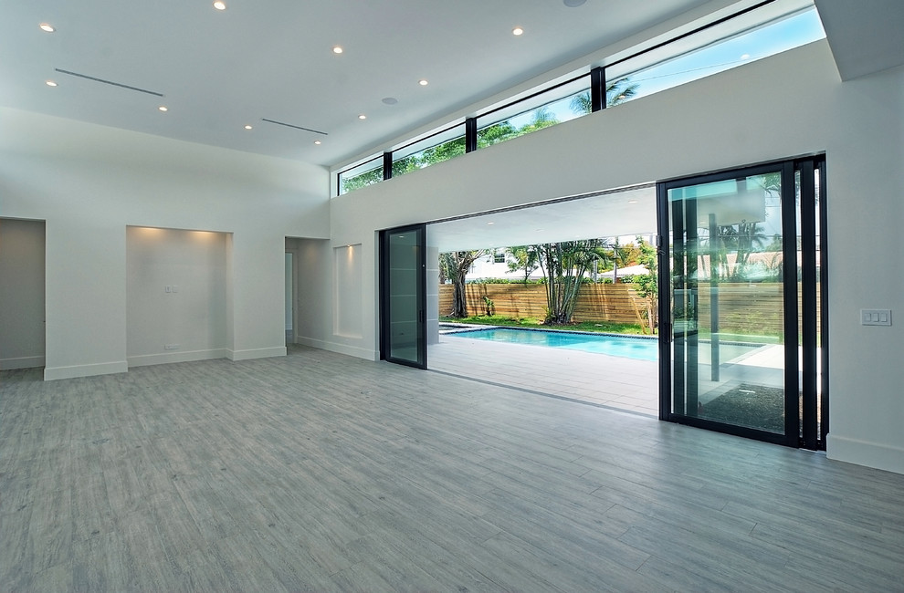 Example of a large trendy open concept painted wood floor and gray floor family room design in Miami with white walls, no fireplace and no tv