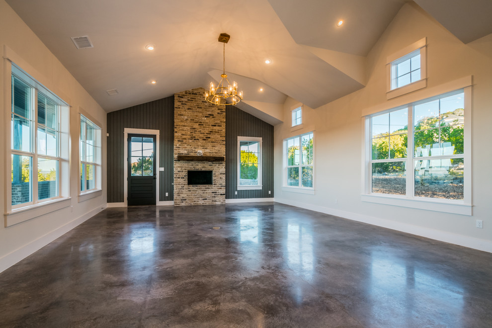 Cottage concrete floor family room photo in Austin with beige walls, a standard fireplace and a brick fireplace