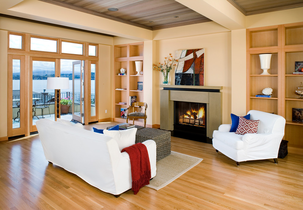 Photo of a contemporary games room in Seattle with beige walls, light hardwood flooring, a standard fireplace and a concrete fireplace surround.