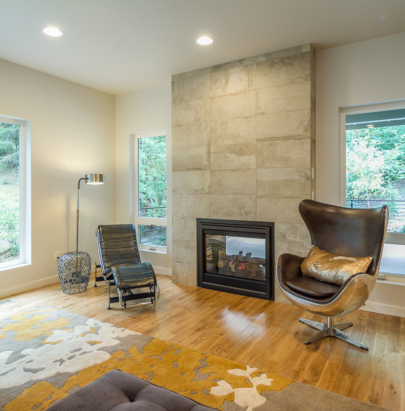 Modelo de sala de estar vintage con paredes blancas, suelo de madera clara, chimenea de doble cara y marco de chimenea de baldosas y/o azulejos