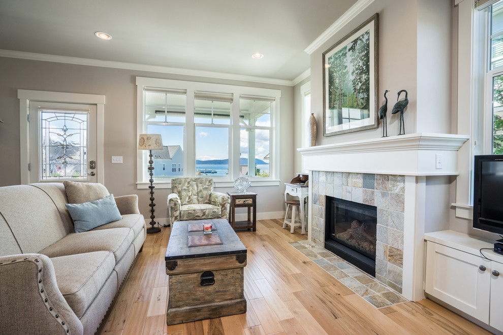 Photo of a medium sized coastal open plan games room in Seattle with beige walls, light hardwood flooring, a standard fireplace and a stone fireplace surround.