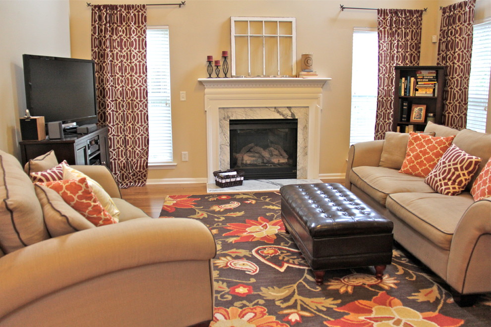 Großes, Offenes Klassisches Wohnzimmer mit freistehendem TV, beiger Wandfarbe, Kamin und Kaminumrandung aus Stein in Charlotte