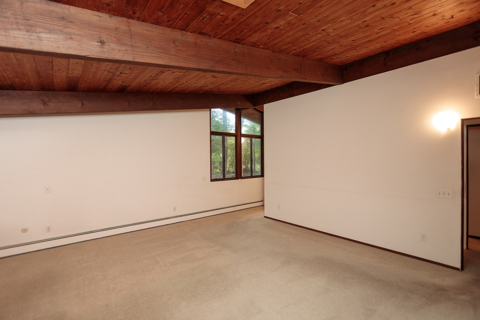 Ejemplo de sala de estar cerrada retro grande con paredes blancas, moqueta, todas las chimeneas, marco de chimenea de ladrillo y suelo beige