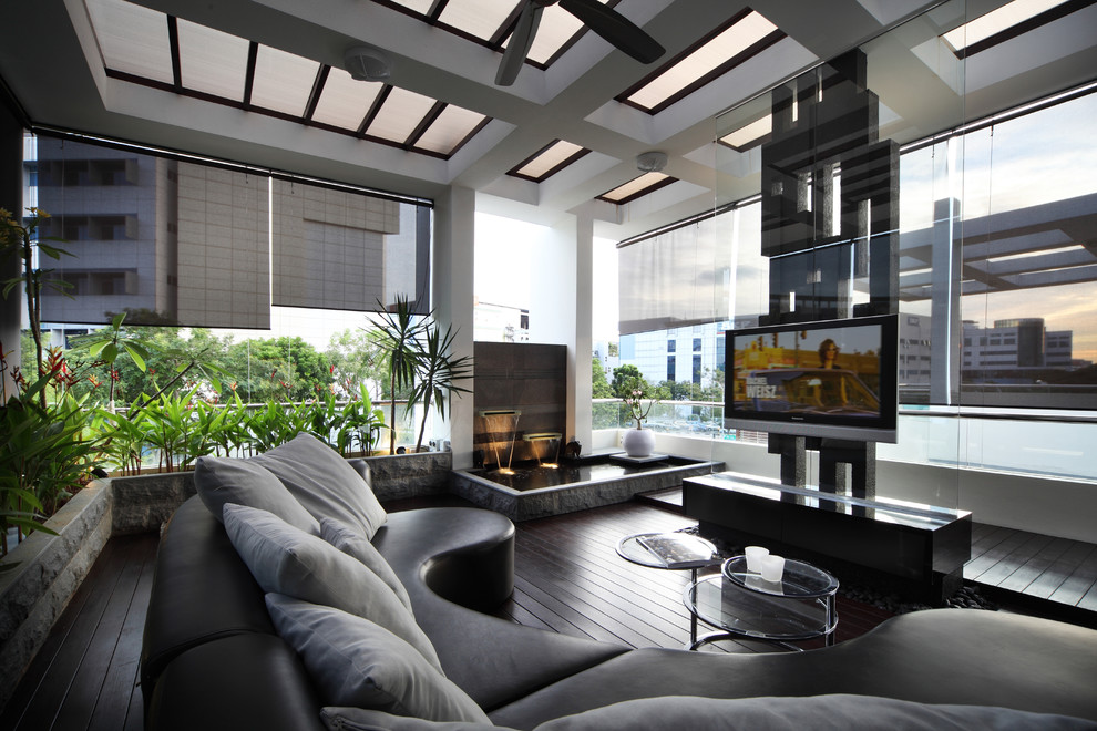 Imagen de sala de estar contemporánea con suelo de madera oscura y televisor colgado en la pared