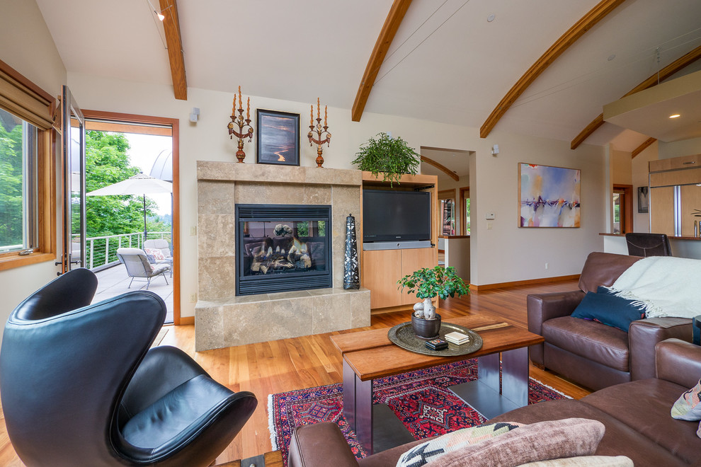 Exemple d'une salle de séjour tendance ouverte avec un mur beige, un sol en bois brun, une cheminée standard et un téléviseur indépendant.