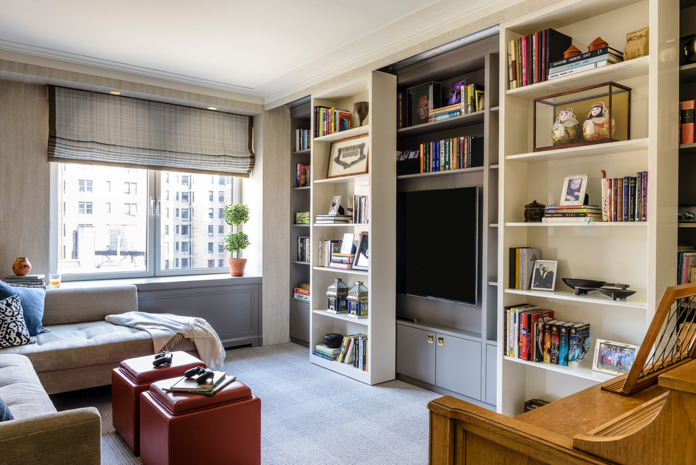 Cette photo montre une salle de séjour chic de taille moyenne et fermée avec une bibliothèque ou un coin lecture, un mur gris, moquette, aucune cheminée et un téléviseur encastré.