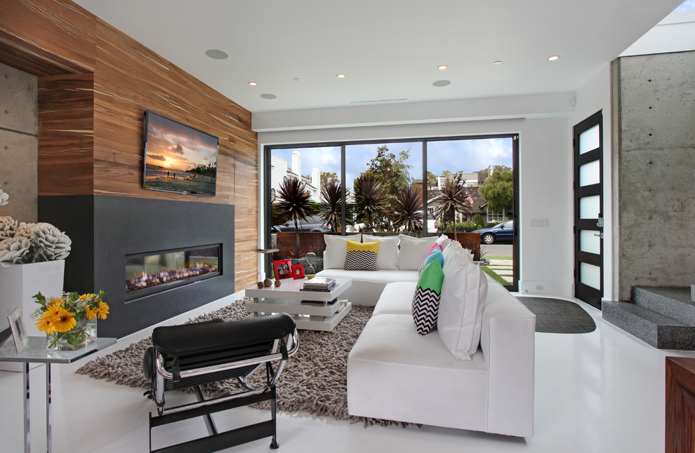 Trendy white floor family room photo in Orange County with white walls, a ribbon fireplace and a wall-mounted tv