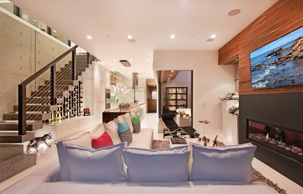 Стильный дизайн: открытая гостиная комната в современном стиле с горизонтальным камином и телевизором на стене - последний тренд