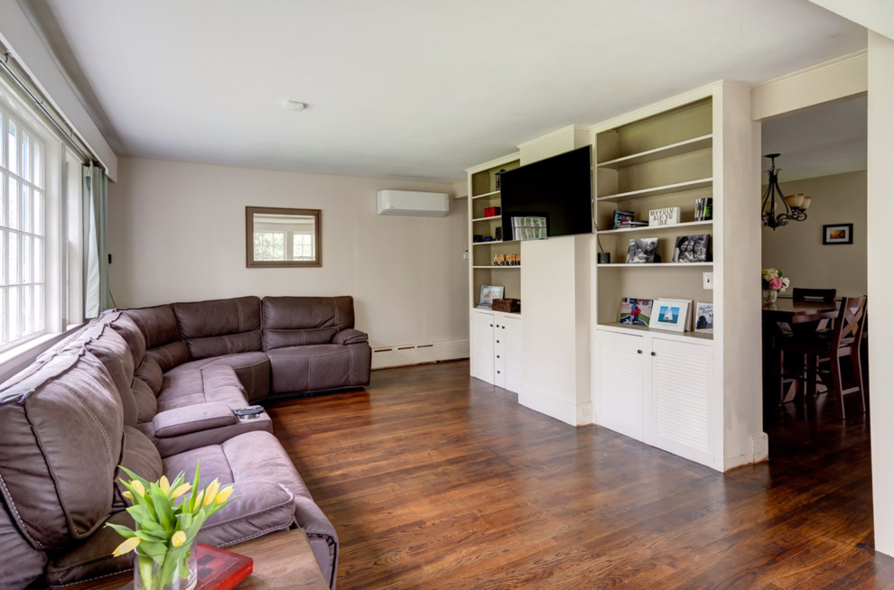 Immagine di un grande soggiorno country chiuso con pareti bianche, pavimento in legno massello medio e TV a parete
