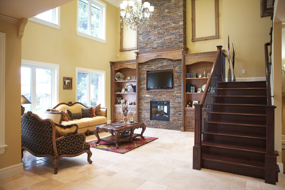 Photo of a large mediterranean open plan games room in Vancouver with limestone flooring, a two-sided fireplace, a stone fireplace surround, a wall mounted tv and beige walls.