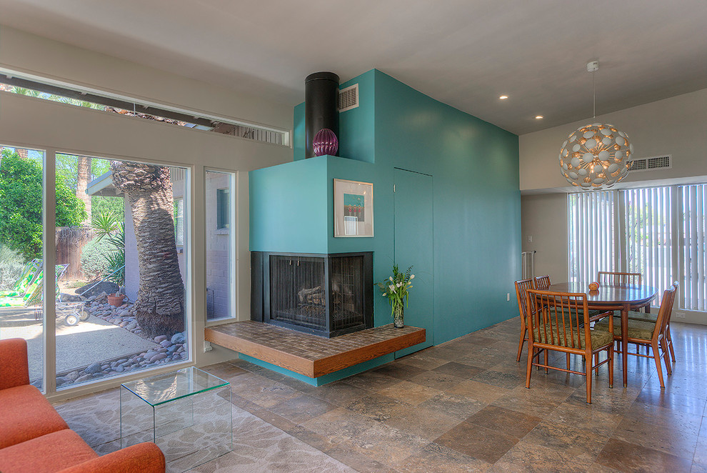 フェニックスにある高級な小さなミッドセンチュリースタイルのおしゃれなオープンリビング (グレーの壁、トラバーチンの床、コーナー設置型暖炉、テレビなし) の写真