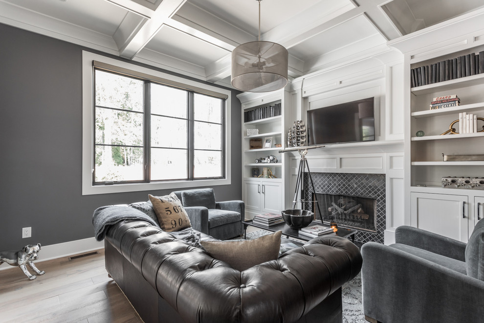 Diseño de sala de estar clásica renovada grande con paredes grises, suelo de madera en tonos medios, todas las chimeneas, televisor colgado en la pared y suelo marrón