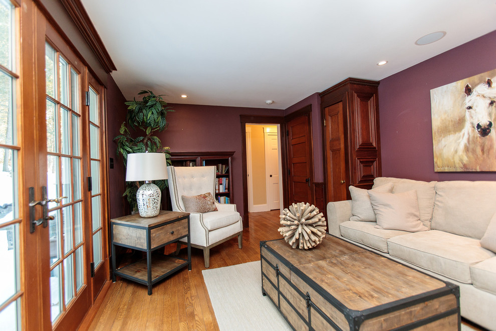 Family room library - mid-sized traditional enclosed medium tone wood floor family room library idea in Boston with purple walls