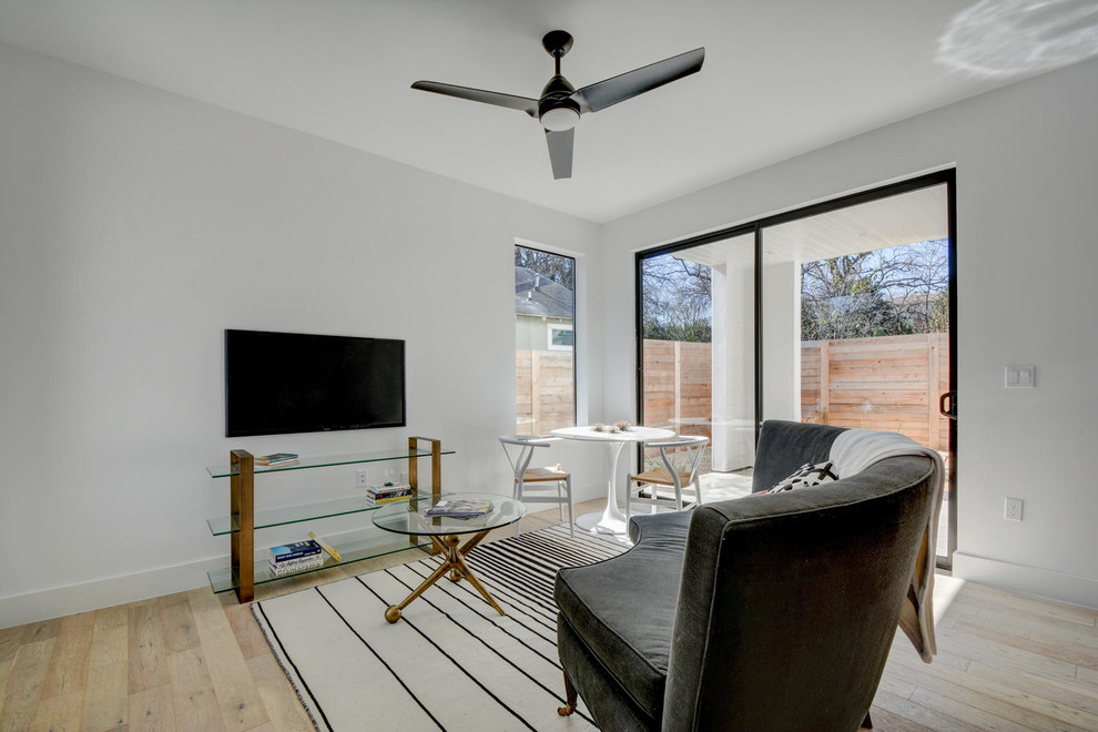 На фото: открытая гостиная комната среднего размера в стиле модернизм с белыми стенами, светлым паркетным полом и телевизором на стене без камина