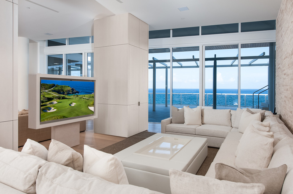 Diseño de sala de estar abierta actual con suelo de madera en tonos medios y pared multimedia