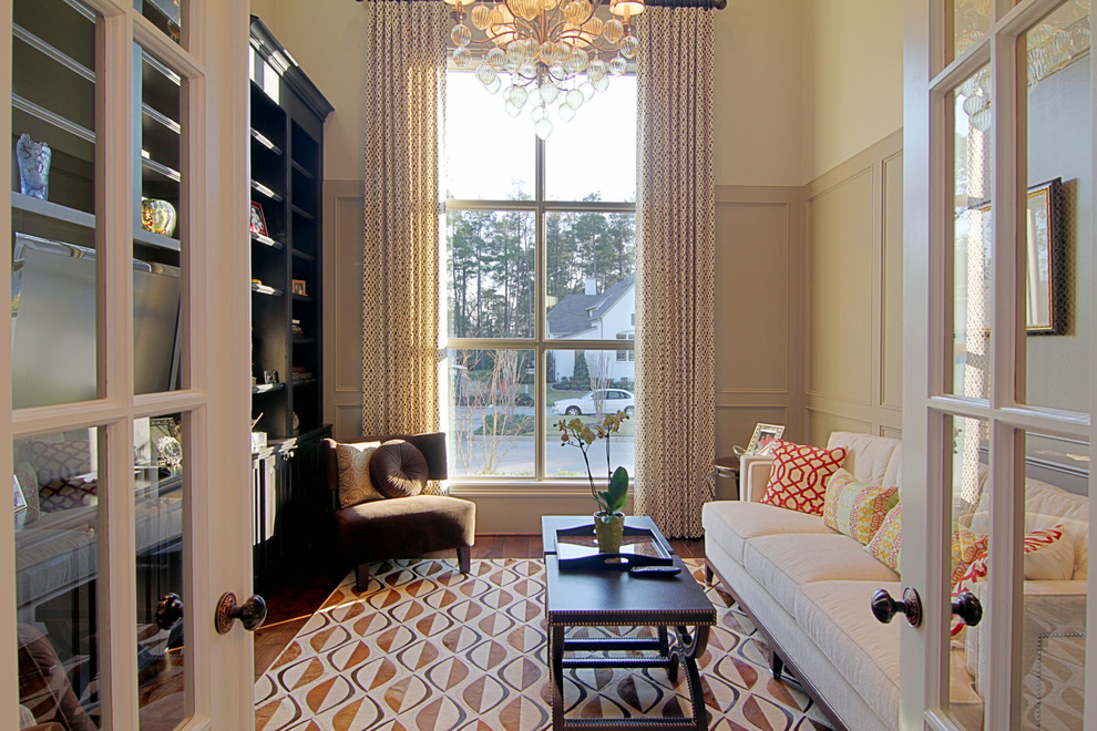 Foto de sala de estar cerrada clásica sin chimenea con paredes beige y suelo de madera en tonos medios