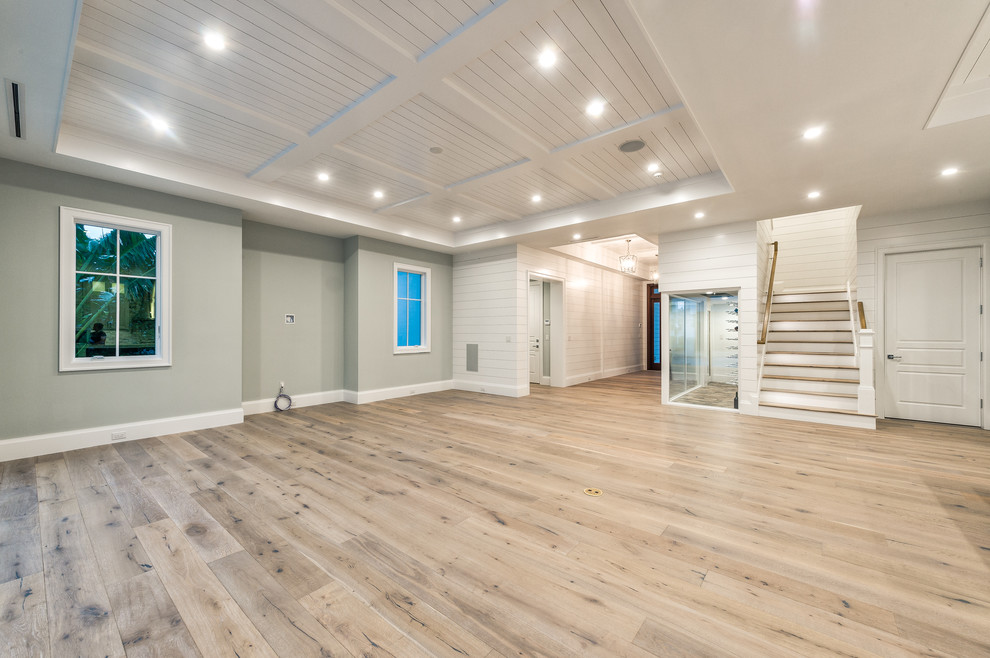 Großes, Offenes Wohnzimmer mit grauer Wandfarbe, hellem Holzboden, TV-Wand und braunem Boden