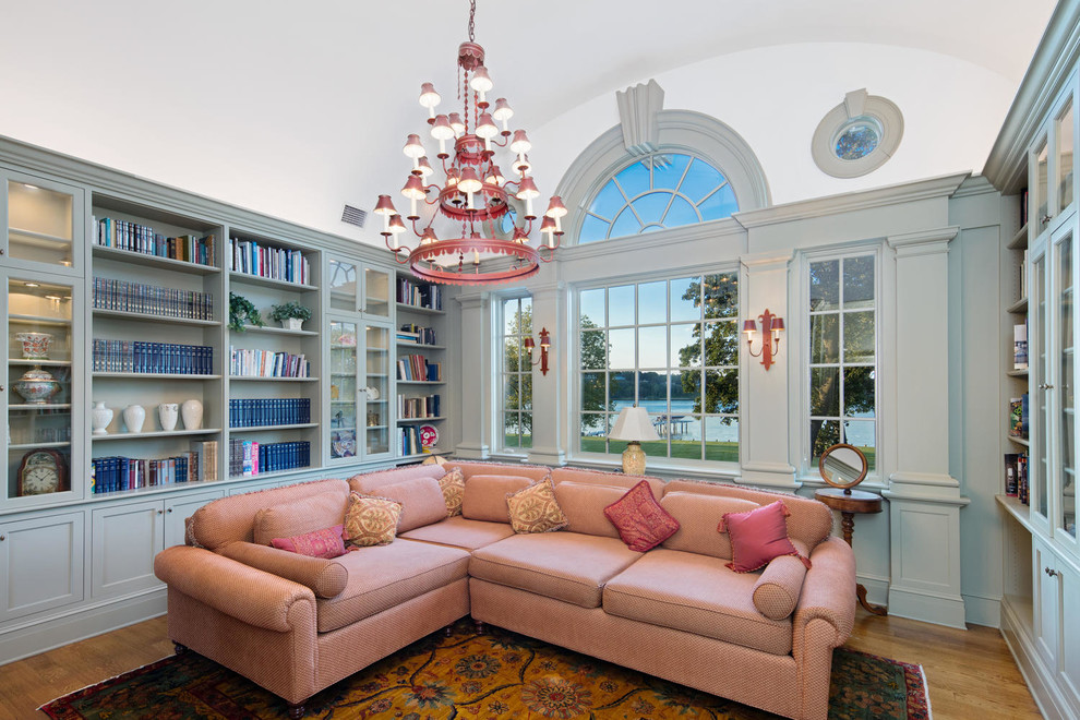 Example of a classic enclosed medium tone wood floor and brown floor family room library design in New York with blue walls
