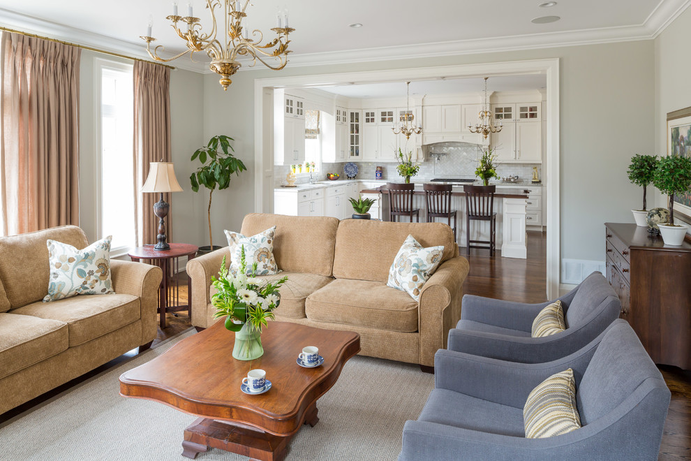 Imagen de sala de estar abierta clásica grande con paredes grises y suelo de madera en tonos medios