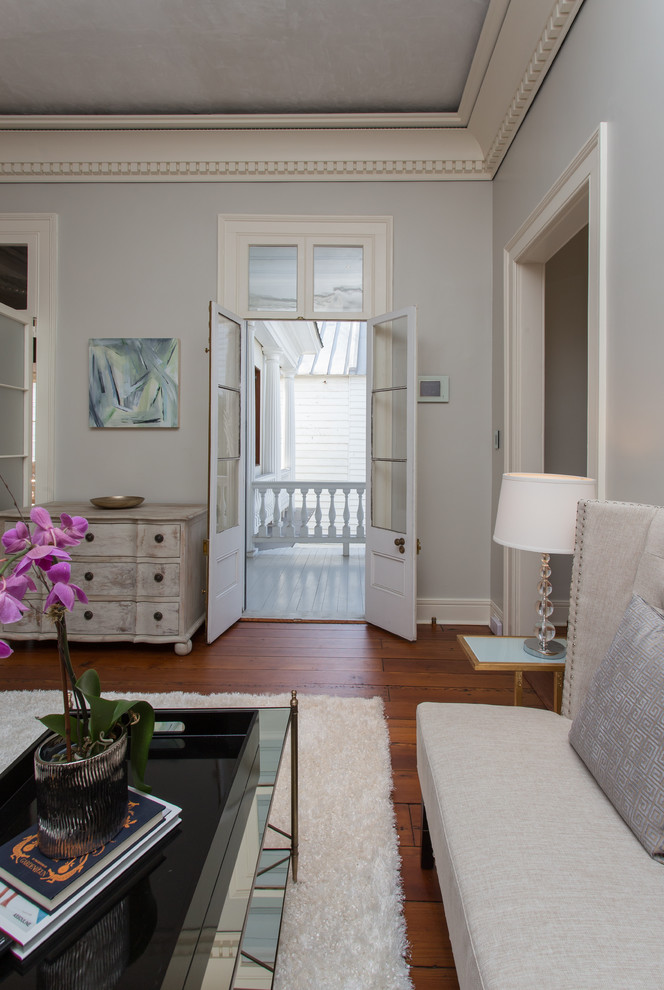 Foto de sala de estar abierta clásica grande con paredes grises, suelo de madera en tonos medios y todas las chimeneas