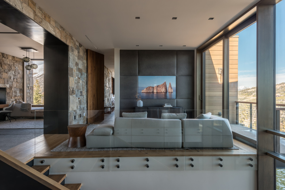 Offenes Rustikales Wohnzimmer ohne Kamin mit braunem Holzboden, TV-Wand und Wandpaneelen in Sonstige