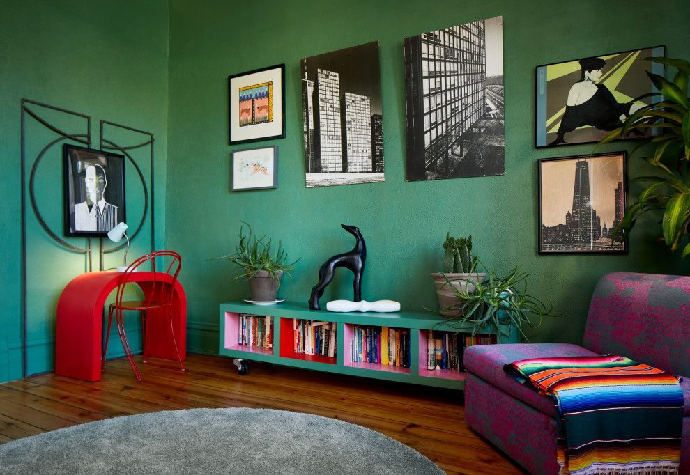 На фото: гостиная комната среднего размера в стиле фьюжн с с книжными шкафами и полками, зелеными стенами и темным паркетным полом
