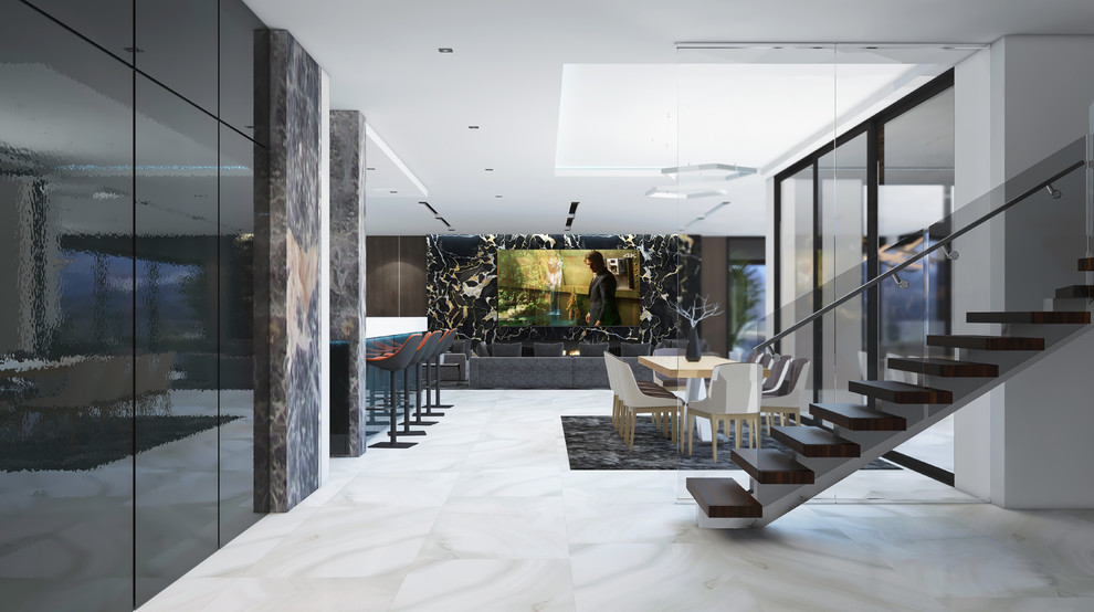 На фото: огромная открытая гостиная комната в стиле модернизм с коричневыми стенами, мраморным полом, стандартным камином, фасадом камина из камня, телевизором на стене, белым полом и сводчатым потолком
