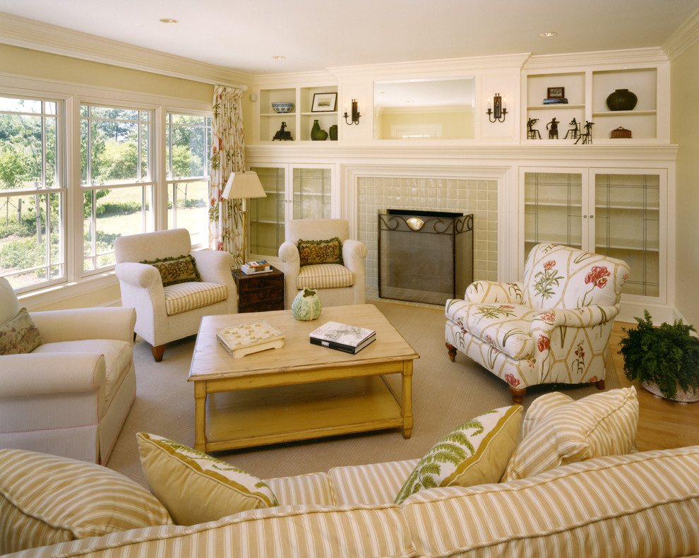 Imagen de sala de estar clásica sin televisor con paredes beige, suelo de madera en tonos medios, todas las chimeneas, marco de chimenea de baldosas y/o azulejos y alfombra