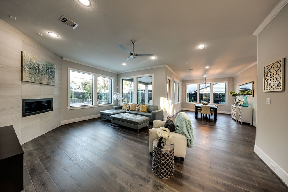 Mittelgroßes, Offenes Modernes Wohnzimmer mit Vinylboden, Gaskamin, gefliester Kaminumrandung und freistehendem TV in Houston