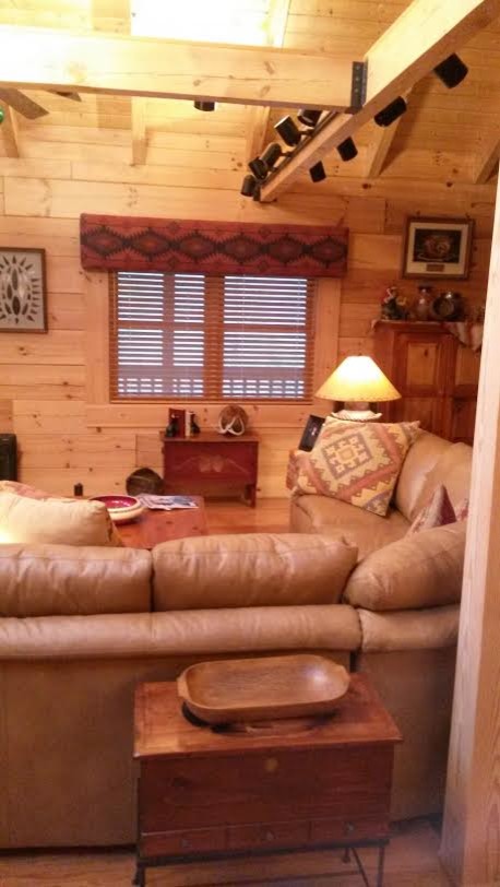 Imagen de sala de estar abierta de estilo americano grande con paredes marrones, suelo de madera clara, todas las chimeneas y marco de chimenea de piedra