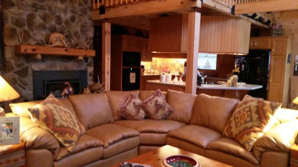 Modelo de sala de estar de estilo americano grande con paredes marrones, todas las chimeneas y marco de chimenea de piedra